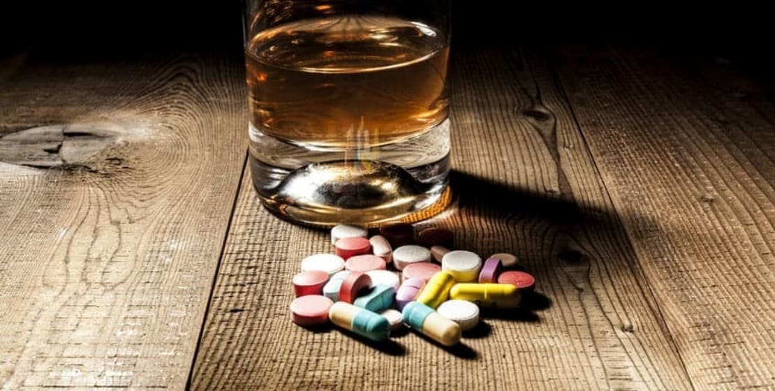 алкоголь и таблетки на столе